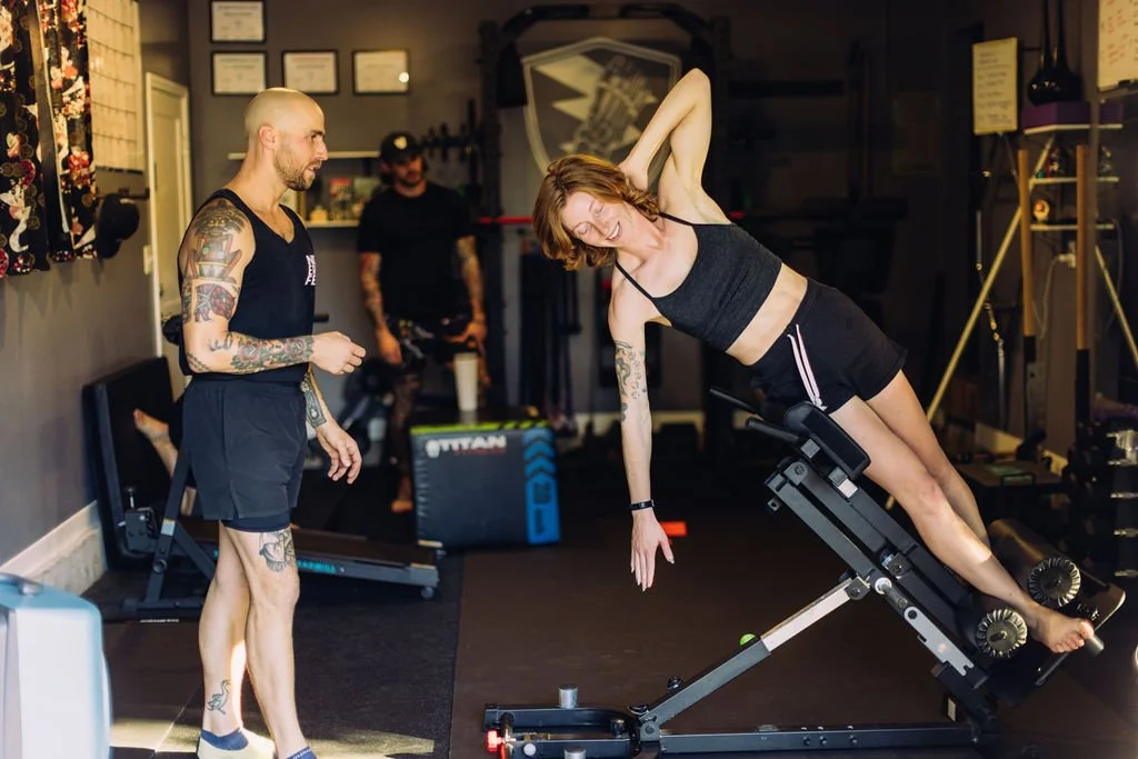 Adam coaching a client through a side bend at the No Easy Feet studio