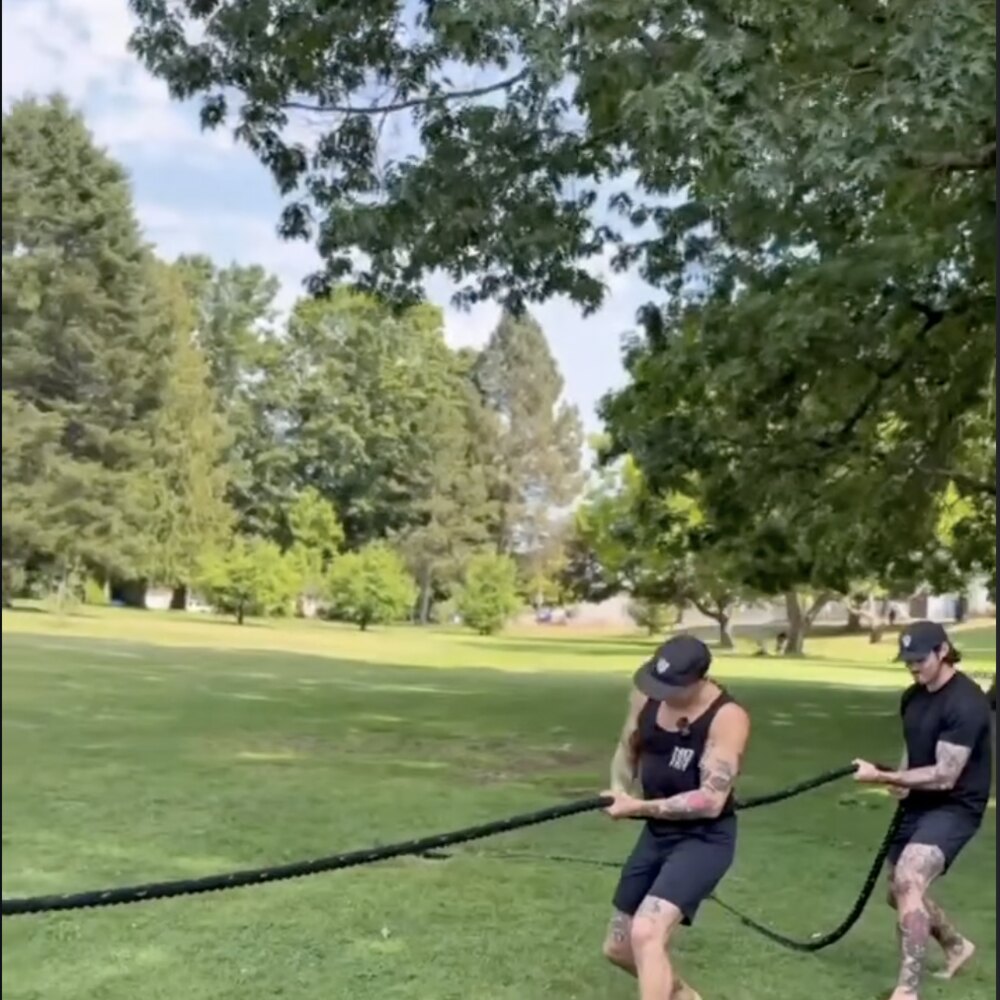 Two coaches battle-rope training at the park during the No Easy Feet Games